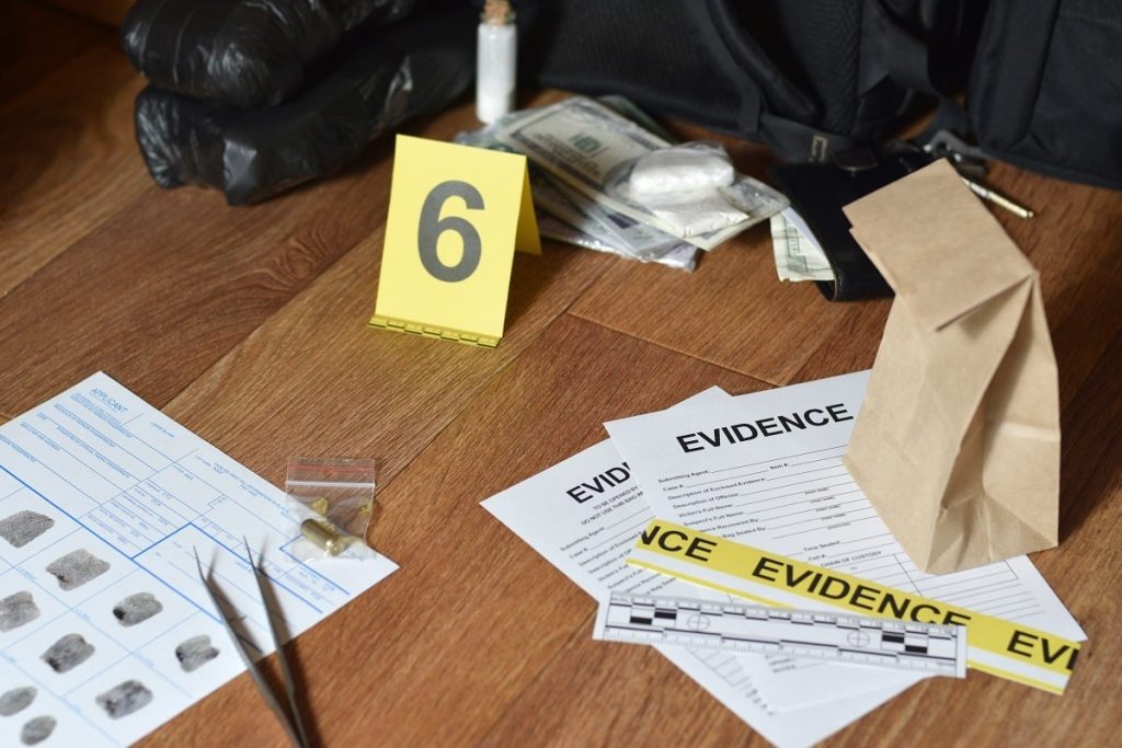 Different types of physical evidence scattered around a crime scene.